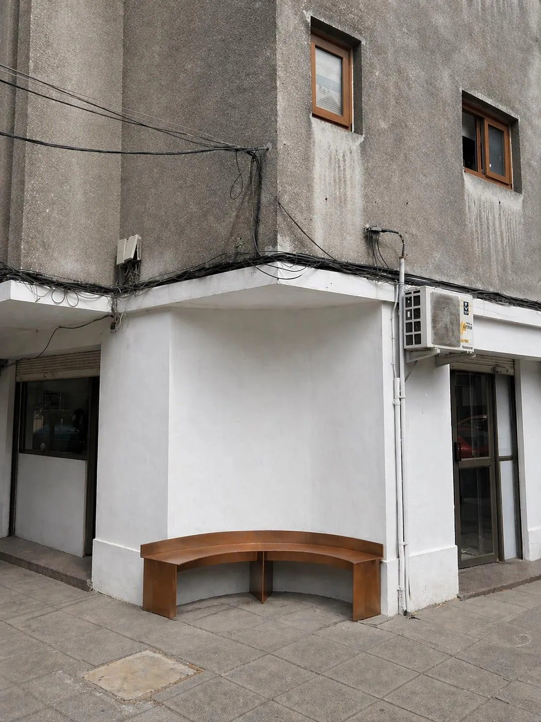 La esquina de la casa con su banca a la calle