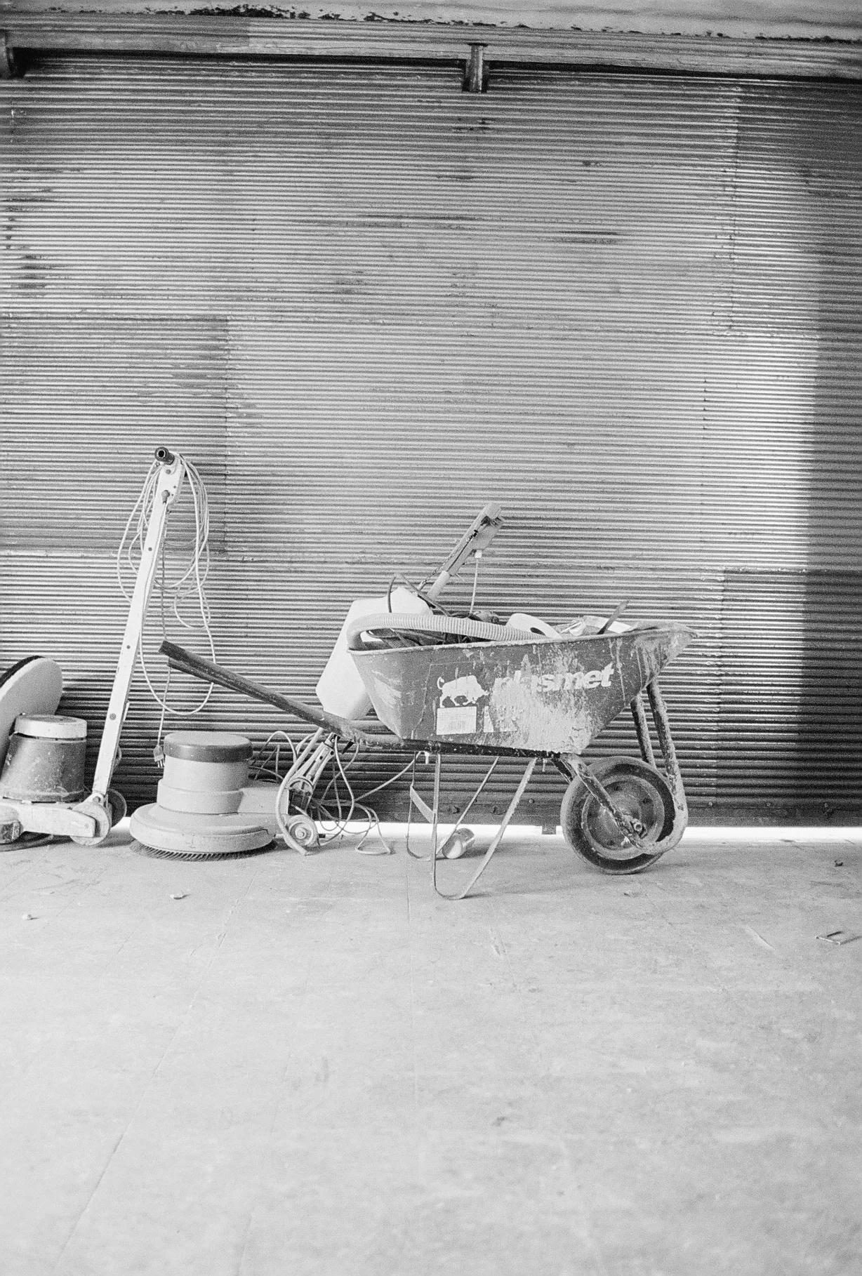 La persiana del local con las herramientas de la obra